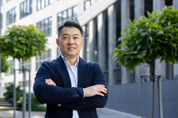 istock Confident businessman standing outdoors with arms crossed in urban setting 2107421233