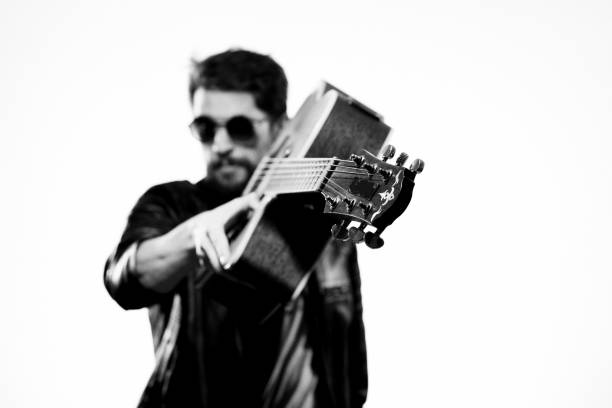 istock A man plays the guitar in a black leather jacket with sunglasses on a light background 2107433860