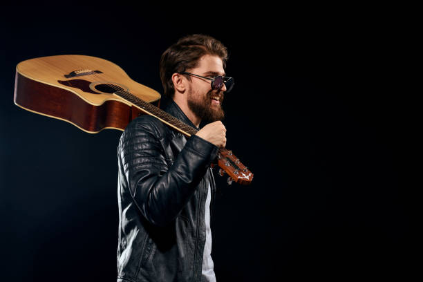 istock A man with a guitar in his hands leather jacket music performance rock star modern style dark background 2107435941