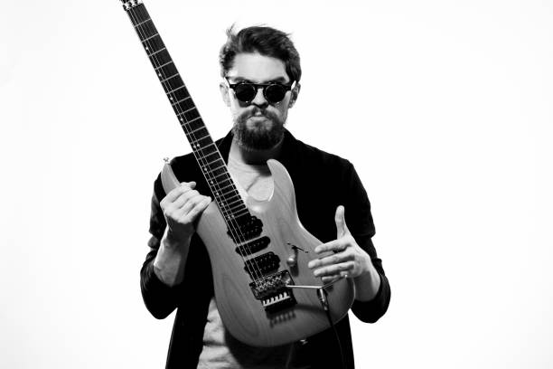istock A man holds a guitar in his hands black leather jacket dark glasses music performance light background 2107437000