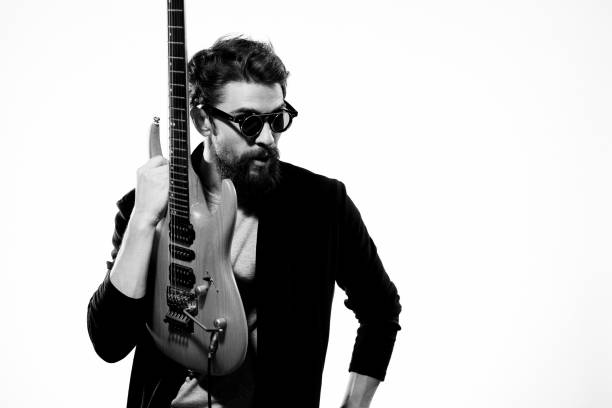 Young guitarist jumping with a guitar on stage. About 25 years old, Caucasian male.