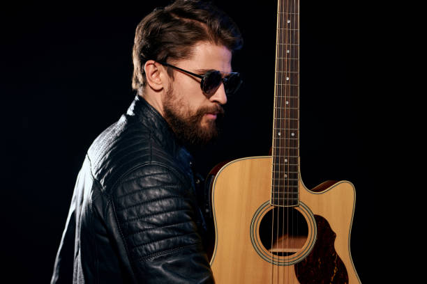 istock A man with a guitar in his hands leather jacket music performance rock star modern style dark background 2107444812