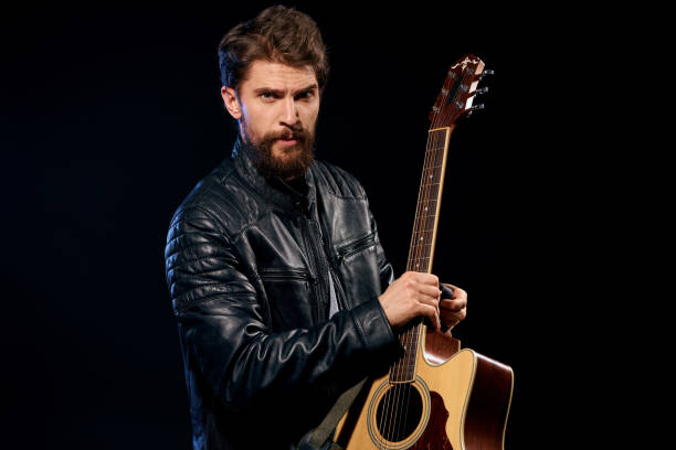 istock A man with a guitar in his hands leather jacket music performance rock star modern style dark background 2107449558
