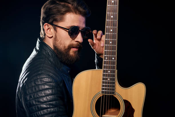 istock A man with a guitar in his hands leather jacket music performance rock star modern style dark background 2107453753