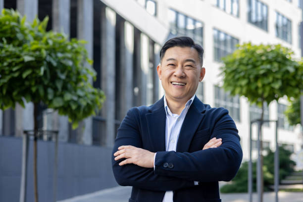 istock Confident businessman smiling outdoors with arms crossed in urban setting 2107455845
