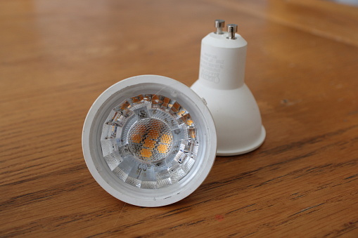 Two led spotlight bulbs up close on a wooden table