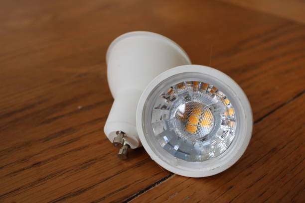 istock Two led spotlight bulbs up close on a wooden table 2107459550