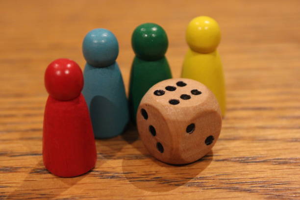 istock Wooden dice and painted toy figures on table, perspective focus 2107460068