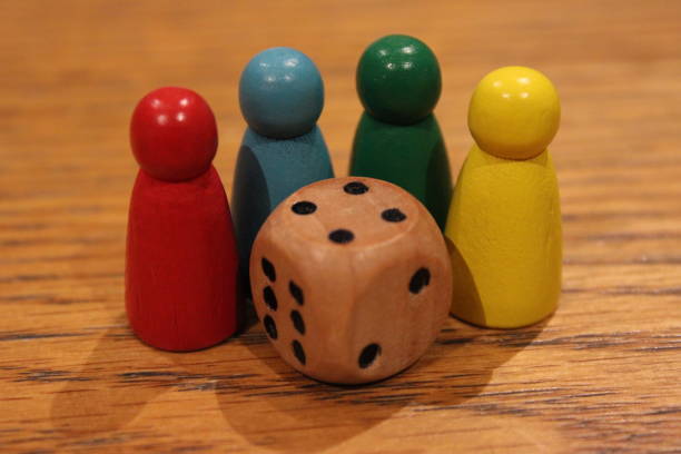 istock Wooden dice and painted toy figures on table, perspective focus 2107460070
