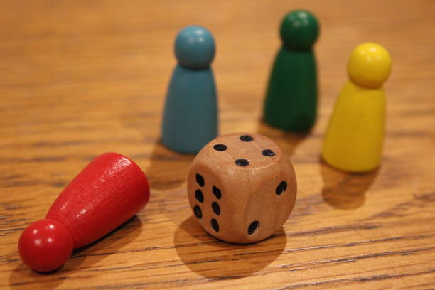 istock Wooden dice and painted toy figures on table, perspective focus 2107460080