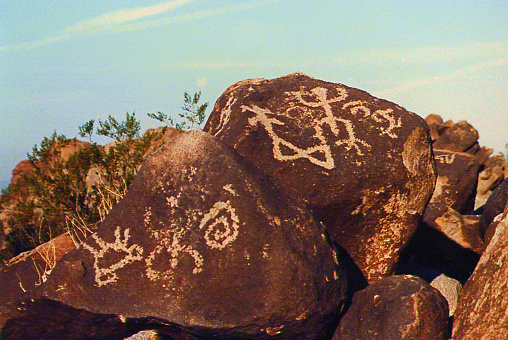 Collection of petroglyphs seen on the naturally rusty colored boulders at Painted Rocks State Park in Arizona.