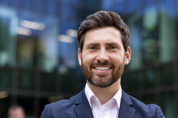 istock Confident professional man smiling in suit against modern office building 2107472168