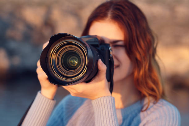 istock woman with professional camera outdoors in mountains front view 2107488627