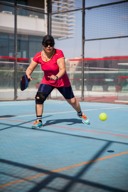 빨간 저지를 입은 여성 피클볼 선수가 공을 치기 위해 움직입니다. - paddle ball racket ball table tennis racket 뉴스 사진 이미지