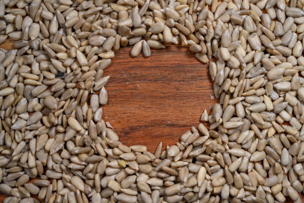 Sunflower shelled seeds on wooden board, top view, close-up