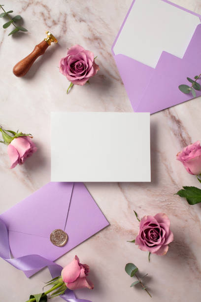 istock Wedding invitation card with purple envelopes and roses. Flat lay, top view, copy space. 2107506291
