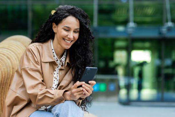 istock Smiling hispanic businesswoman using smartphone during lunch break outside 2107512054