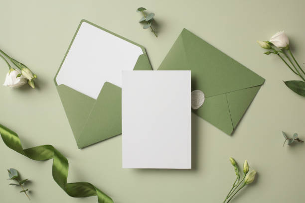 istock Wedding invitation mockup with green envelopes and flowers on pastel green table. Wedding stationery. 2107516231