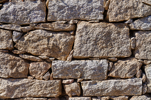 Old stone wall texture. Fortified stone wall of an ancient fortress from the Roman Empire.