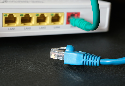 Cables with the RJ45 connector in front of the network device. Communication concept background. Selected focus.