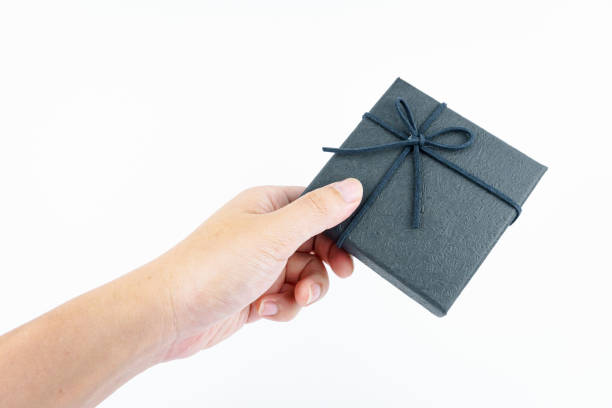 istock Hand holding black gift box on white background. 2107581705