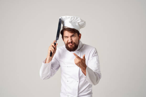 istock a man in a chef's uniform with a frying pan in hand isolated background 2107598735