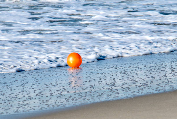 istock Bright Orange Ball on the Beach 2107607152