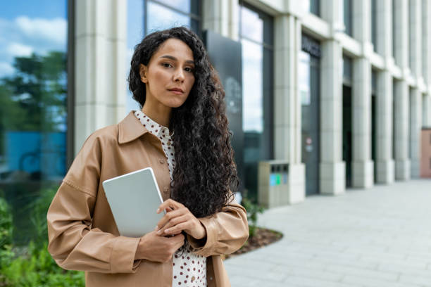 istock Professional woman holding a tablet outside a modern office building 2107609268