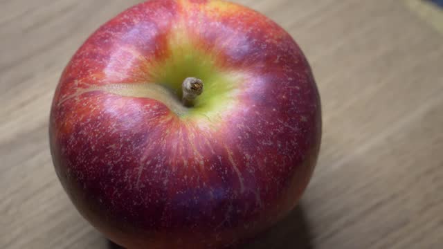 One large ripe gala apple in close-up. Video with rotating red apple.