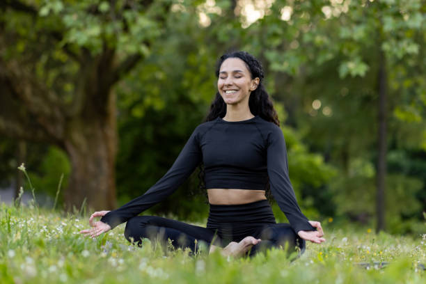 istock Smiling woman practicing yoga in tranquil outdoor setting at dusk 2107676573