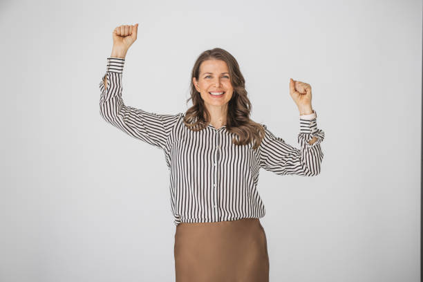 portrait of confident young woman dressing casual business clothes with fists on air looking away on isolated white background