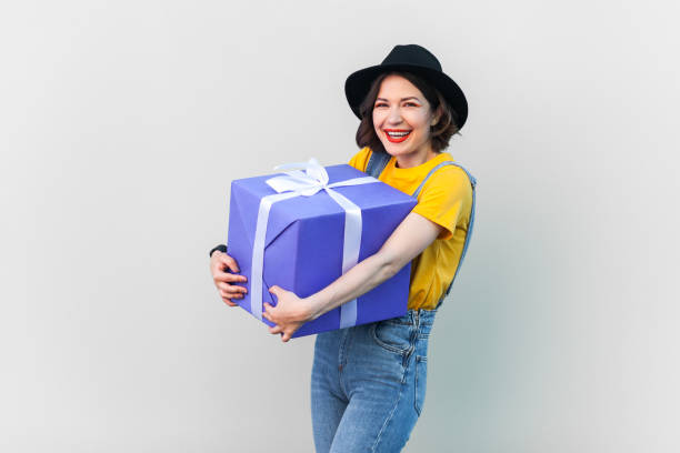 istock Extremely happy optimistic hipster woman embracing big wrapped box with present. 2107694730