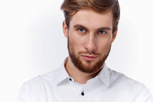 blond man with a thick beard and mustache in a white shirt on a light background. High quality photo