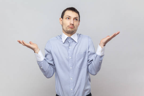 istock Puzzled confused handsome man with spread hands, shrugging shoulders, having helpless expression. 2107702681