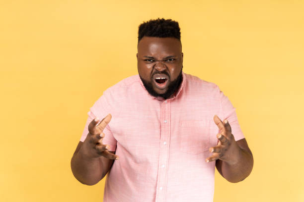 istock Man standing with raised arms, expressing aggression, screaming, frowning face. 2107710667