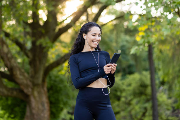istock Active woman pausing her workout to use smartphone in nature 2107784256