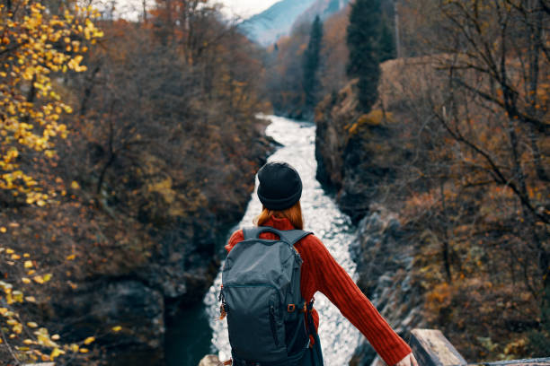 istock woman hiker backpack mountains river fresh air 2107825074