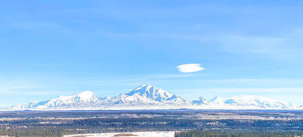 The beauty of the Alaskan Skyline along with its mountains, clouds, and trees, offers stunning views.