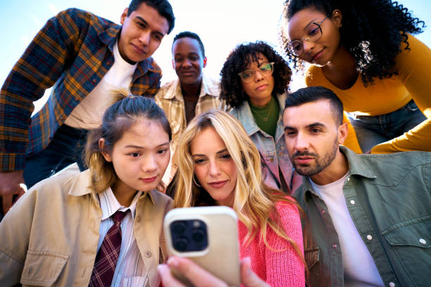 istock A group of happy amazed humans friends in outerwear using mobile smiling watching something funny 2107837133