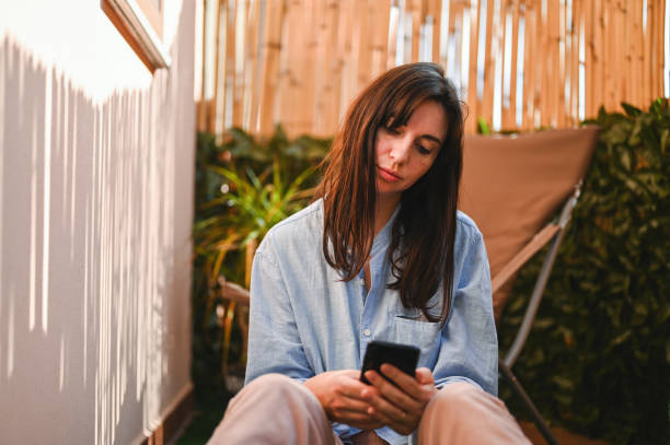 istock Tired woman using mobile phone in terrace. 2107839068