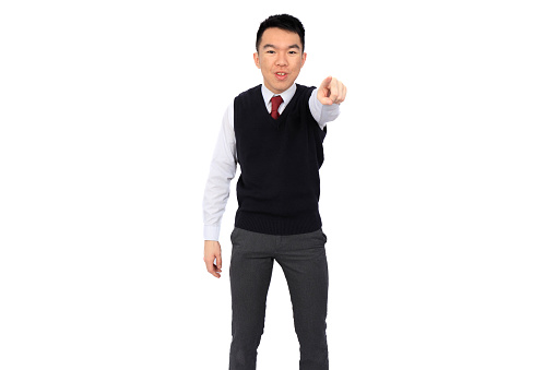 A young Asian high school student is pointing at the camera energetically. He is wearing a black sweater vest over a white shirt and red tie. The background is white and isolated in a studio.