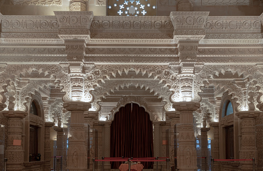 London, UK - Feb 27, 2024 - The Shree Sanatan Hindu Mandir Hindu temple interior architecture with view of intricately carved stone and columns with beautiful artwork. Inside the Shri Sanatan Hindu Temple, Space for text, Selective focus.