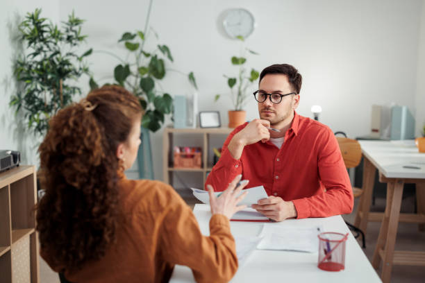 istock Two young business people discussing work at office 2107921555