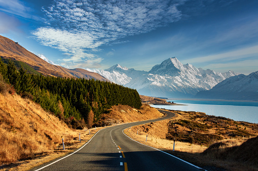 Scenic road winding its way along the shores of the alpine Lake Pukaki with Mt Cook in the background