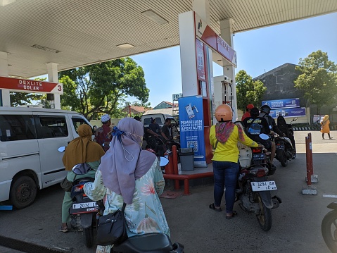 Cilacap, Indonesia - March 24, 2024: The queue of motorbike riders at a gas station is starting to get busy before entering the Eid al-Fitr moment in Indonesia