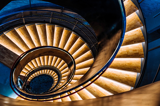 Top shot of a rotating staircase illuminated in yellow light