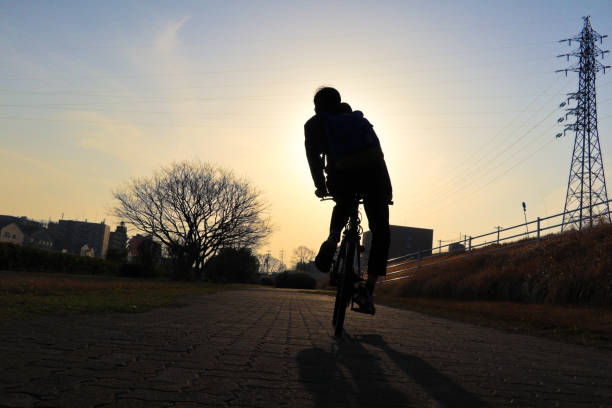 Silhouette man riding a bycicle with beautiful sunset
