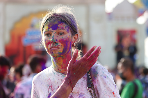 A beautiful girl displays her colorful hands covered in Holi powder during the Holi festival in Pattaya, Thailand.