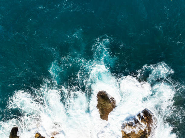 istock Waves crashing on seashore rocks,Top view sea surface waves background 2108354337
