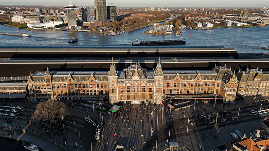 Amsterdam Centraal station is the largest railway station in Amsterdam, North Holland, the Netherlands. A major international railway hub, it is used by 192,000 passengers a day, making it the second busiest railway station in the country after Utrecht Centraal and the most visited Rijksmonument of the Netherlands.\n\nNational and international railway services at Amsterdam Centraal are provided by NS(Nederlandse Spoorwegen), the principal rail operator in the Netherlands. Amsterdam Centraal is the northern terminus of Amsterdam Metro routes 51, 53, 54, and stop for 52 operated by municipal public transport operator GVB. It is also served by a number of GVB tram and ferry routes as well as local and regional bus routes operated by GVB, Connexxion and EBS.\n\nAmsterdam Centraal was designed by Dutch architect Pierre Cuypers and opened in 1889. It features a Gothic, Renaissance Revival station building and a cast iron platform roof spanning approximately 40 metres.\n\nSince 1997, the station building, underground passages, metro station, and the surrounding area have been undergoing major reconstruction and renovation works to accommodate the North-South Line metro route, which was opened on 22 July 2018. Amsterdam Centraal has the second longest railway platform in the Netherlands with a length of 695 metres. Due to the length, each platform may serve two trains, while one embarks from side \